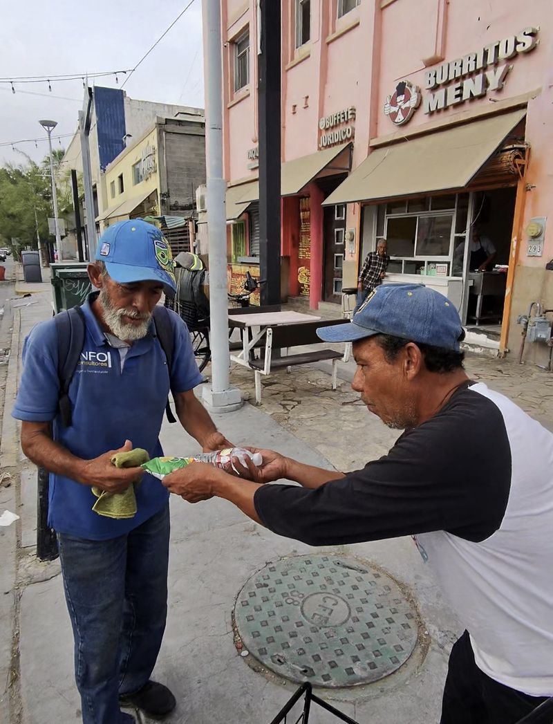 Two men exchanging food and supplies during a community outreach day